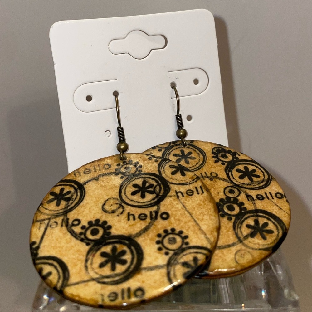 Cute round brown wood earrings with hello and flower graphic design